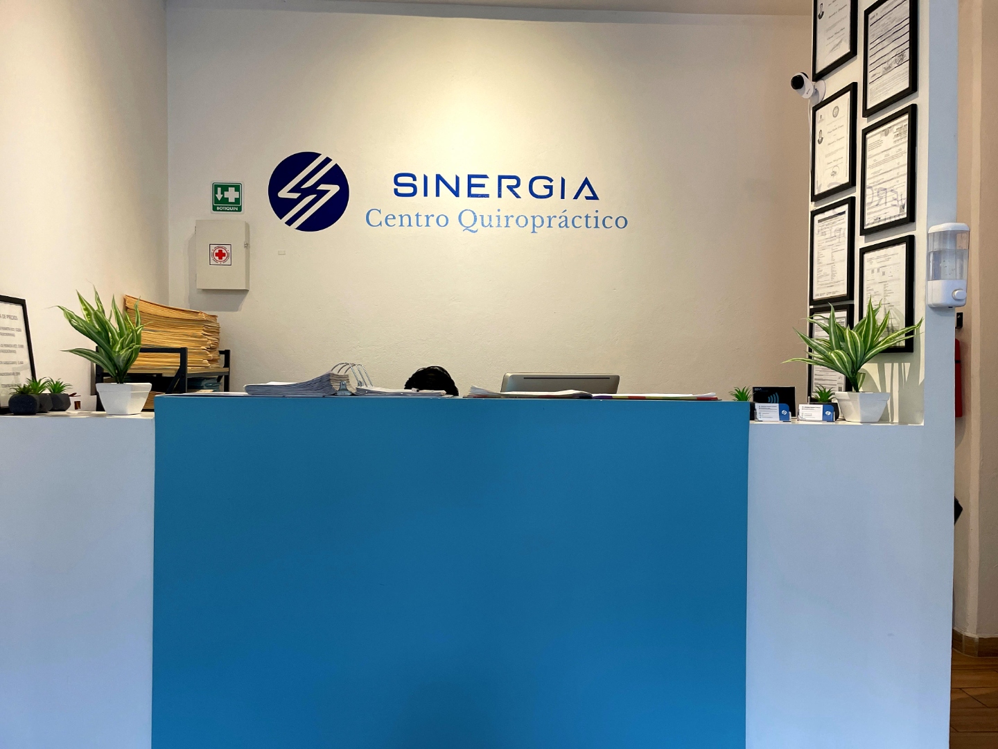 Recepción de Sinergia Centro Quiropráctico con logotipo